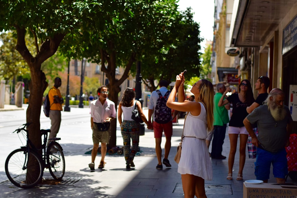 woman holding smartphone near man wearing gray t-shirt