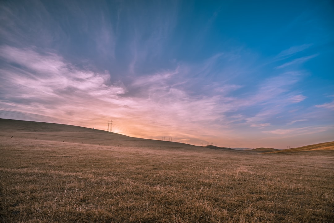 landscape photography of brown field under blue sky