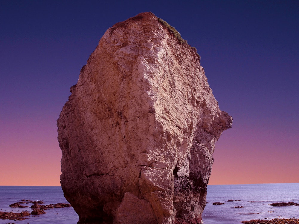 brown rock formation with body of water