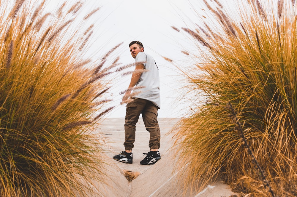 man looking back on tall brown grass