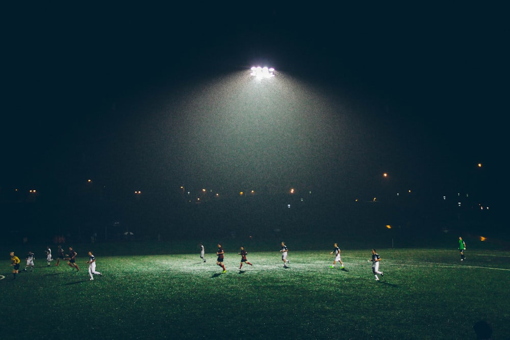 Gruppe von Menschen, die auf dem Fußballplatz Fußball spielen