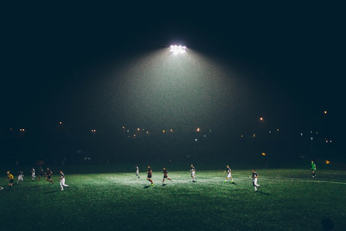 Soccer game being played on a public field with passionate spectators