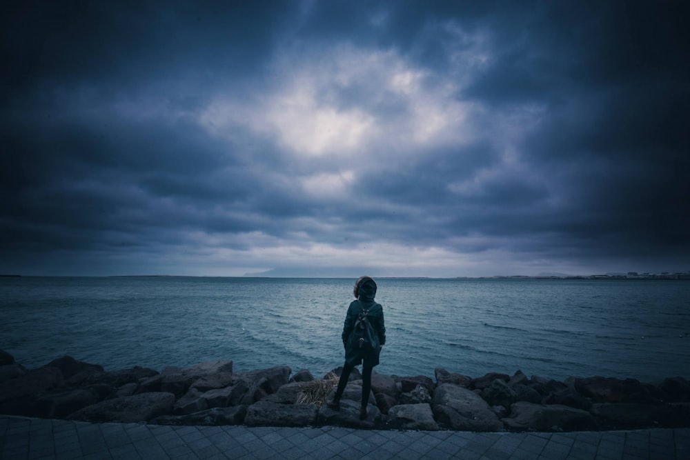 Persona in piedi vicino alla riva del mare