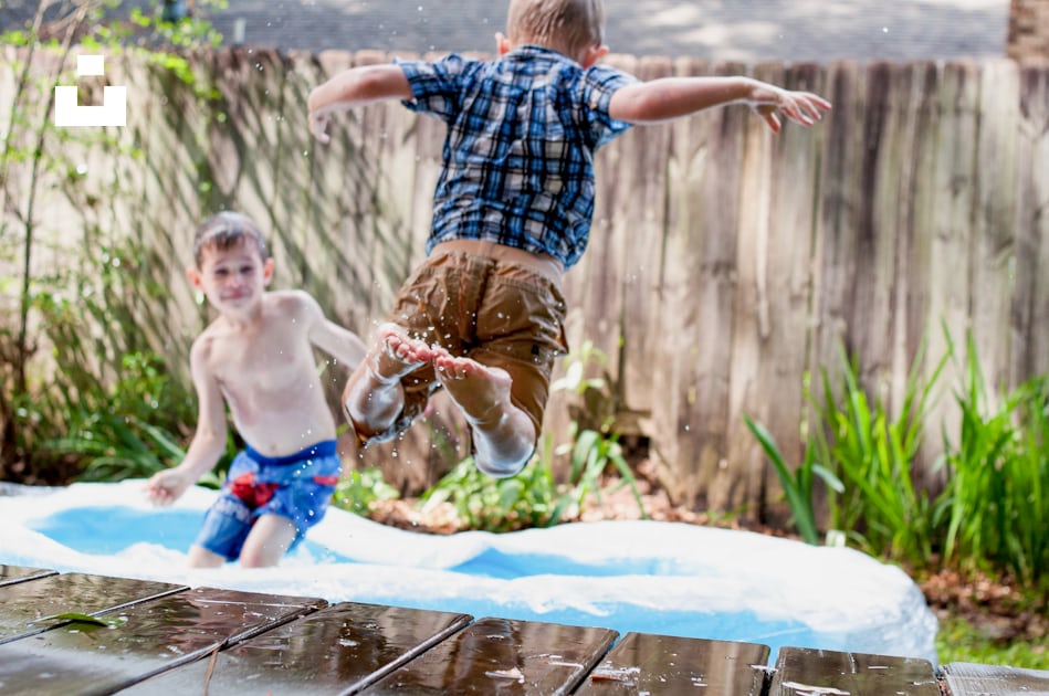 Deux garçons jouant dans la piscine gonflable pendant la journée photo ...