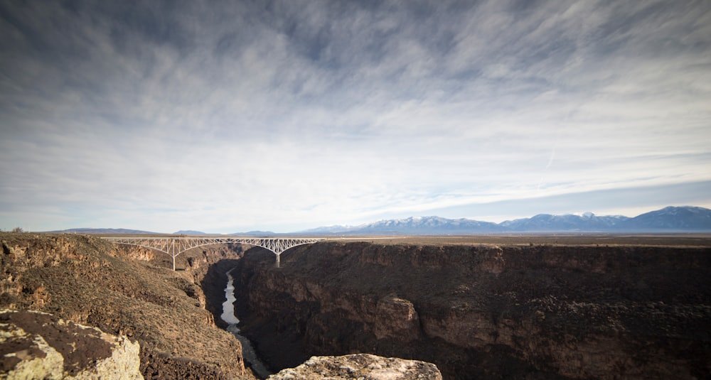 white bridge in between rock mountain