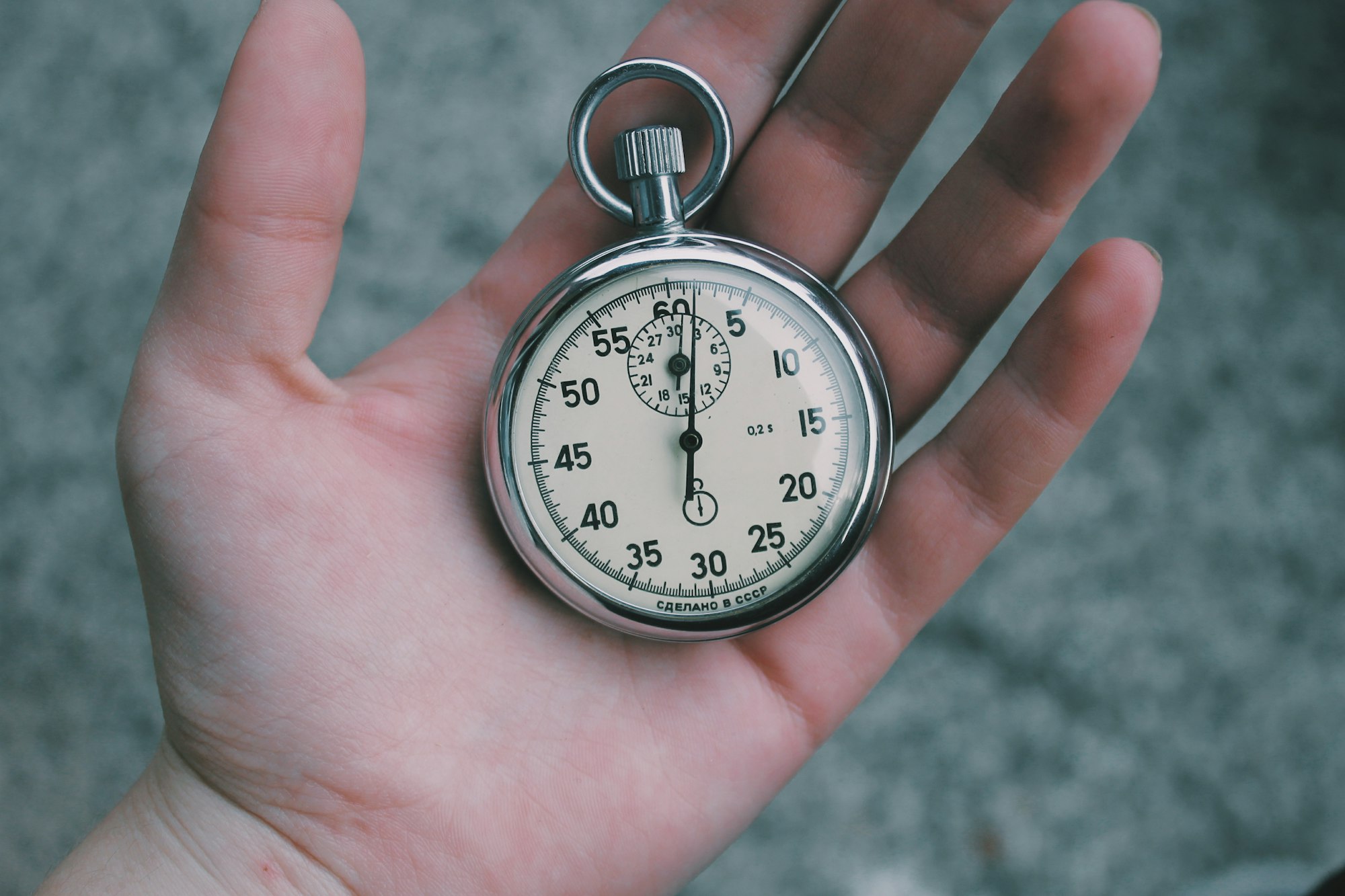 A hand holding a stopwatch