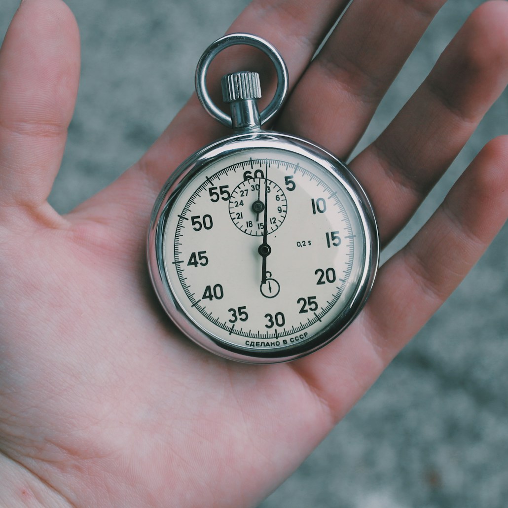 person holding white and silver-colored pocket watch