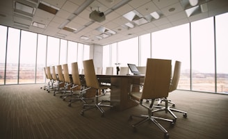 oval brown wooden conference table and chairs inside conference room