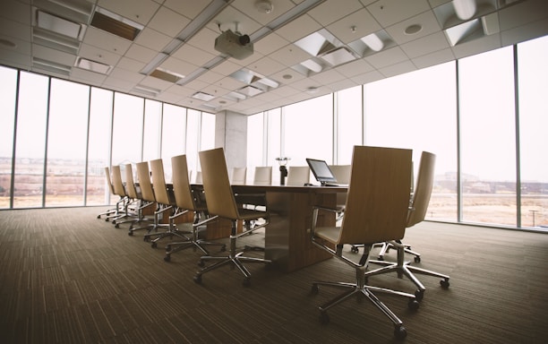 oval brown wooden conference table and chairs inside conference room