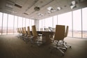 oval brown wooden conference table and chairs inside conference room