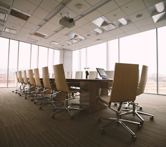 oval brown wooden conference table and chairs inside conference room