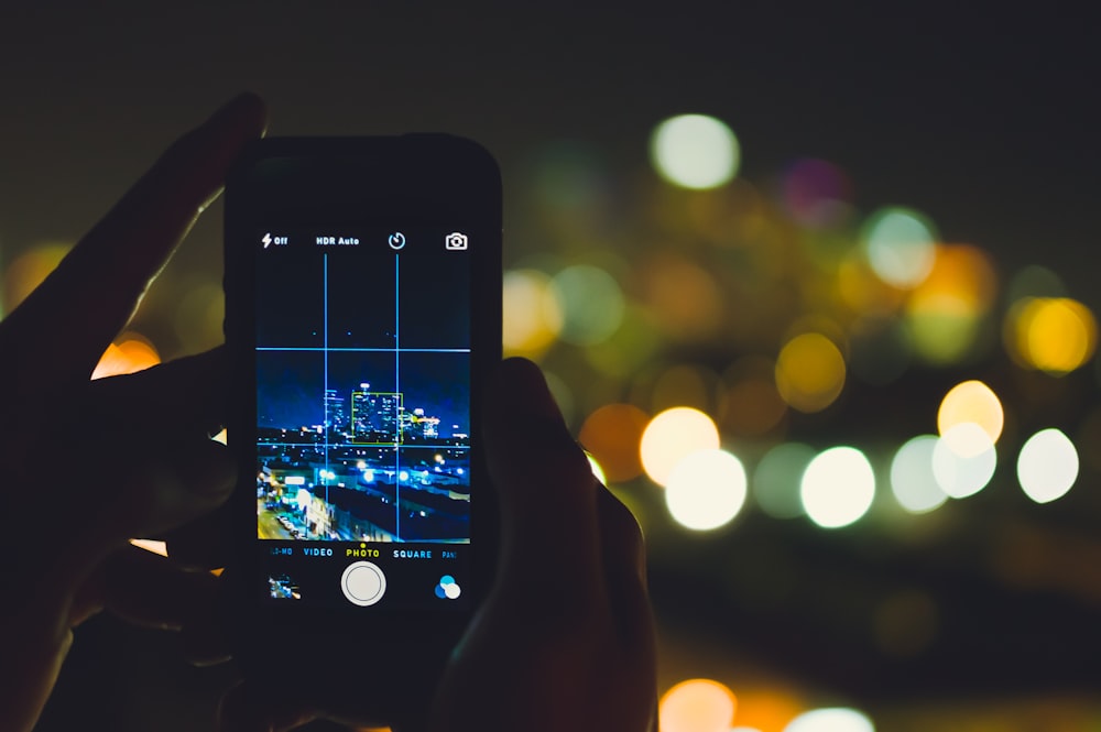 person taking picture of concrete buildings