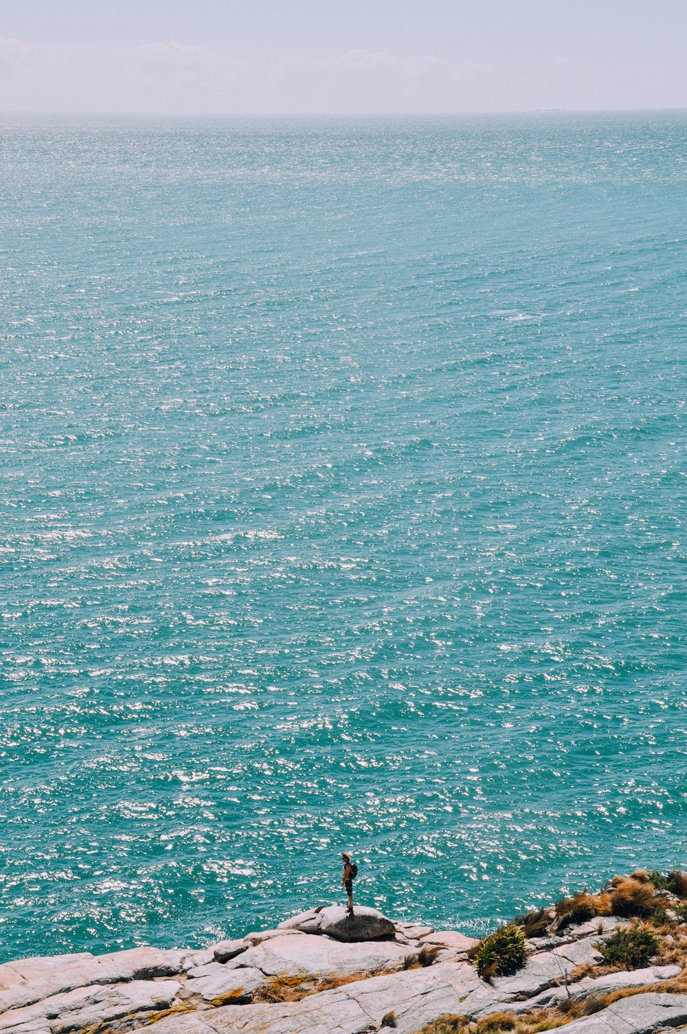 person standing on rock near body of water