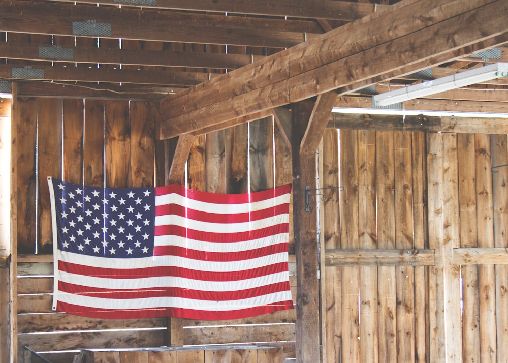 An American flag hanging in a wooden barn