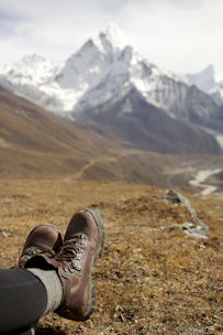 A pair of well-worn climbing shoes resting on rocky terrain.