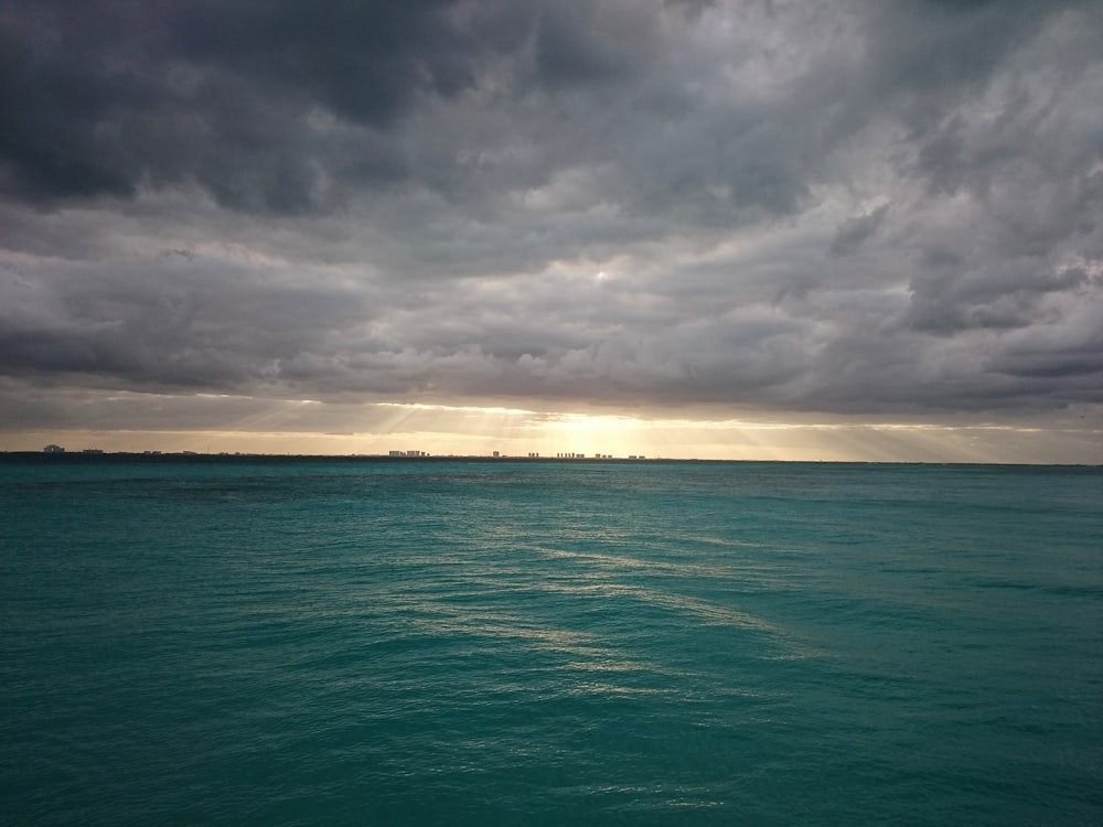 green body of water and white clouds