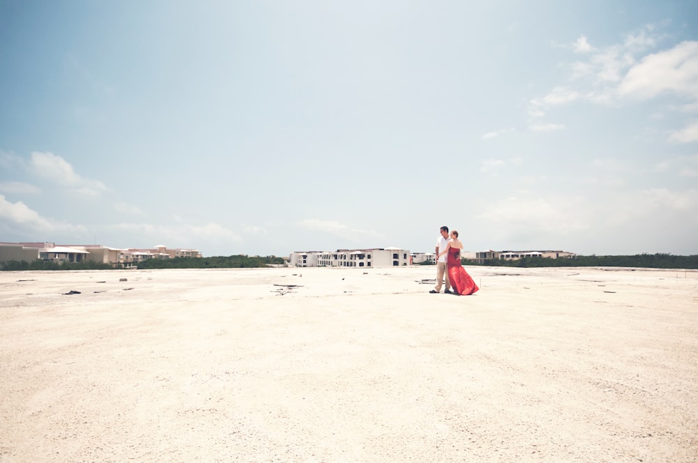 man and woman standing on open field during daytime