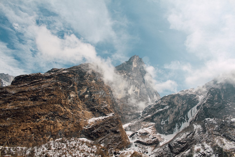 snow covered mountain with clouds