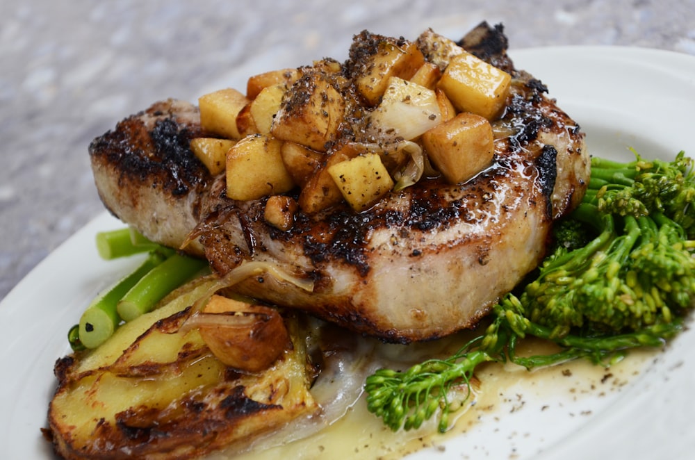 Steak grillé aux légumes sur assiette en céramique blanche