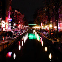 A lively scene of the Navigli district’s canals lined with colorful cafes and lights.