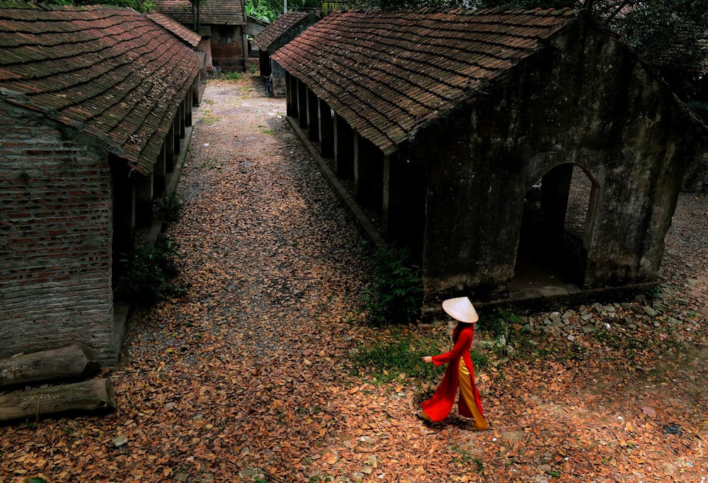 femme marchant près de maisons abandonnées