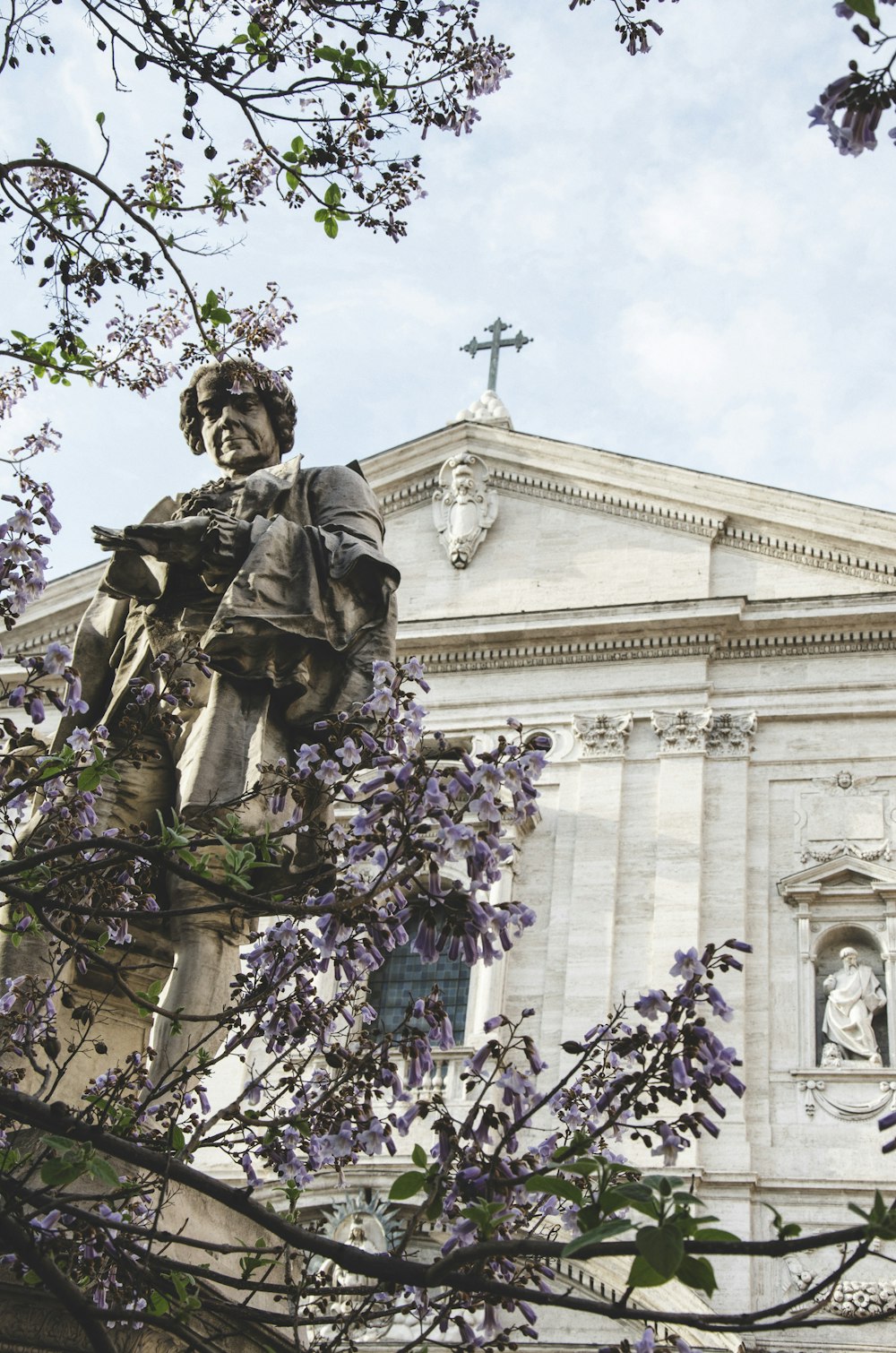 statue in front of white building during daytime