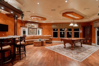 billiard table in center of brown painted room