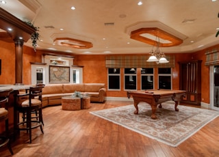 billiard table in center of brown painted room