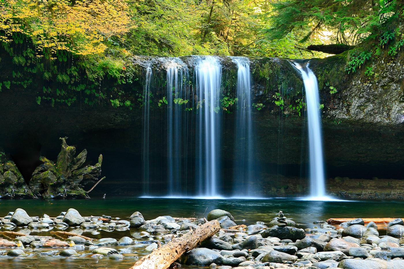 Nuranang Waterfall cascading down a cliff surrounded by lush green forest