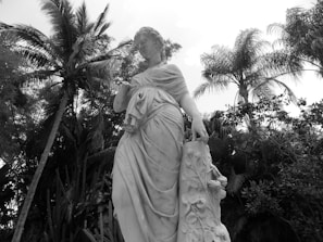 Statue of Sofía Vergara with lush greenery in the background.