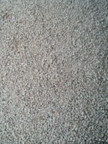 A layer of stones being carefully spread over the dug ground.