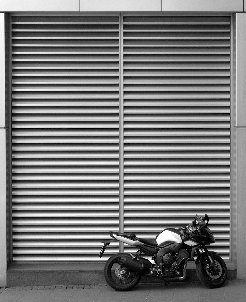 Motocicleta Backbone estacionada al lado de la puerta enrollable