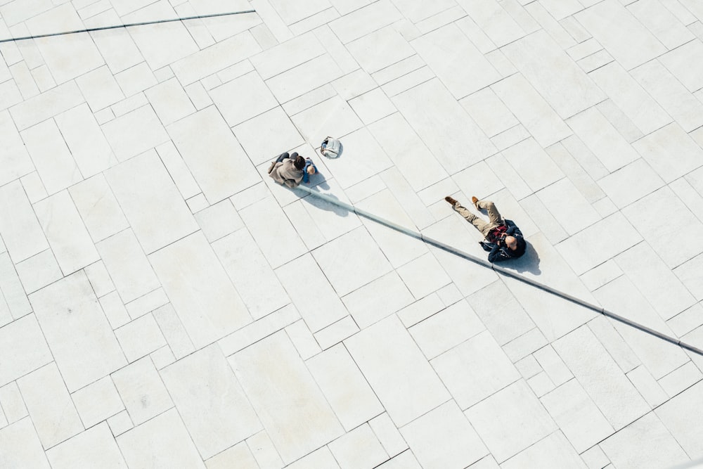 person lying on white concrete pavement during daytime