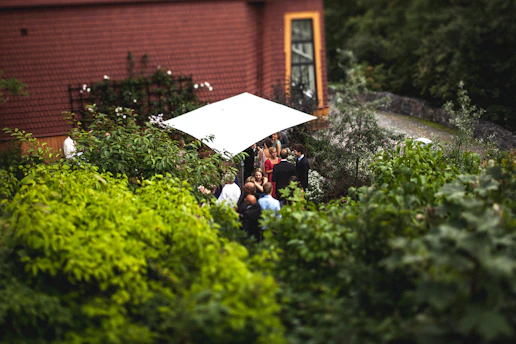 A small group sharing a quiet moment together outdoors, surrounded by tropical greenery and soft natural light.