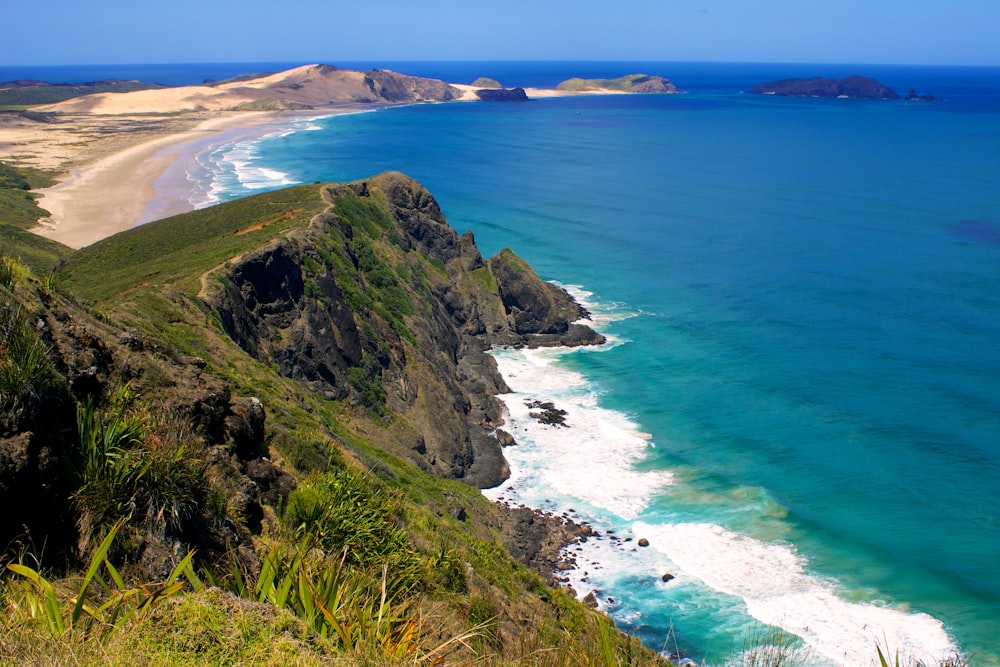 hills in front of sea during daytime