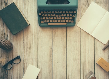 vintage teal typewriter beside book