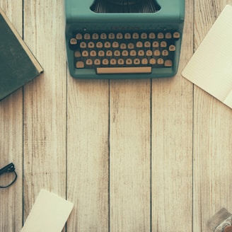 vintage teal typewriter beside book