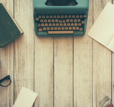 vintage teal typewriter beside book