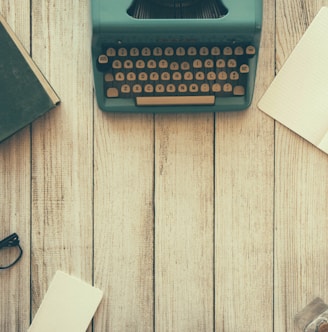 vintage teal typewriter beside book