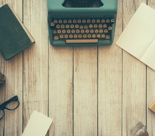 vintage teal typewriter beside book