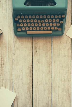 vintage teal typewriter beside book