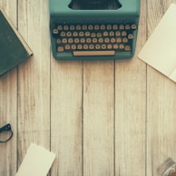 vintage teal typewriter beside book