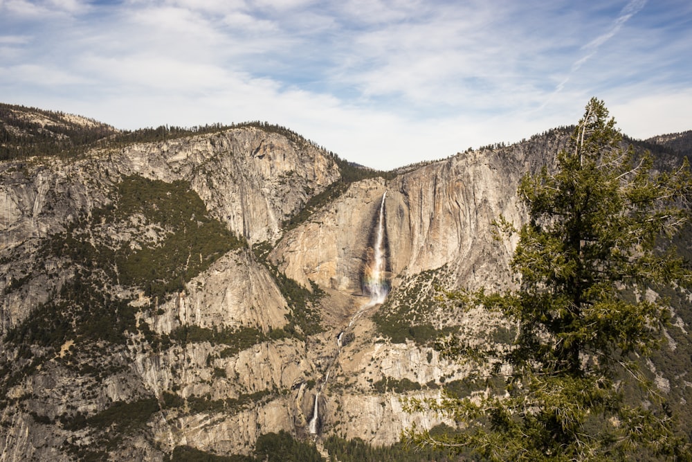 waterfall under cloudy sky