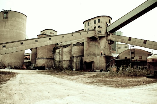 Modern cement factory with large silos and conveyor belts.