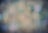 A mosquito is captured in focus against a blurred, dreamy background featuring various shades and light spots.