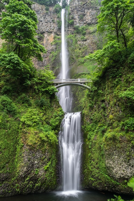 gray concrete bridge and waterfalls during daytime