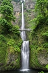 gray concrete bridge and waterfalls during daytime