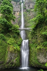 gray concrete bridge and waterfalls during daytime