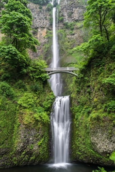 gray concrete bridge and waterfalls during daytime