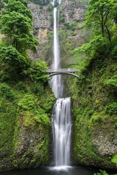 gray concrete bridge and waterfalls during daytime